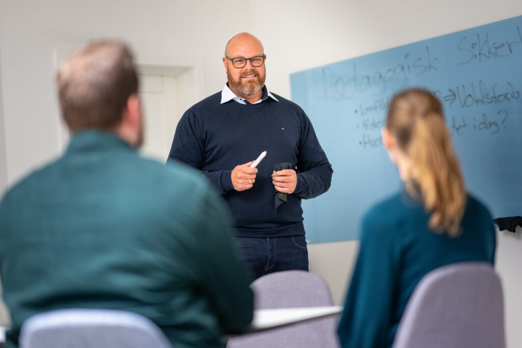 Michael Neigaard står ved en tavle og afholder kursus i afstemt pædagogik.